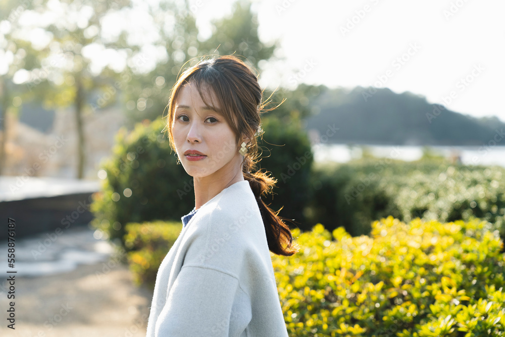 公園で爽やかな光を浴びる女性