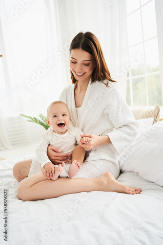 Vertical shot, happy young mother hugging her little newborn son.