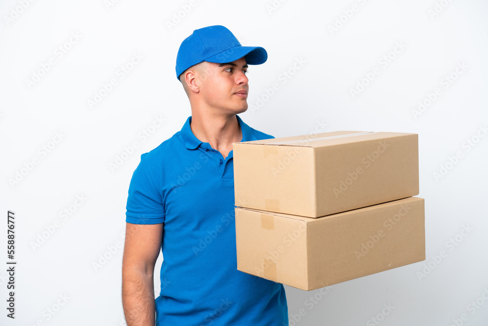 Delivery caucasian man isolated on white background looking to the side Delivery caucasian man isolated on white background looking to the side