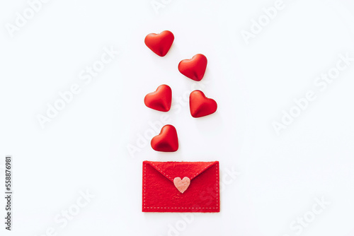Red felt envelope with hearts on white background