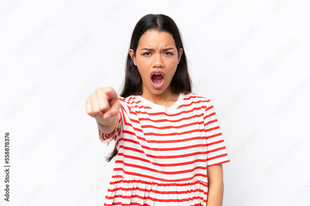 Young Colombian woman isolated on white background frustrated and pointing to the front Young Colombian woman isolated on white background frustrated and pointing to the front