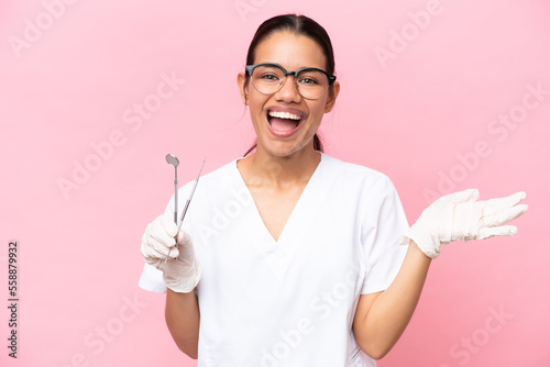 Dentist Colombian woman isolated on pink background with shocked facial expression