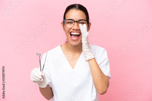 Dentist Colombian woman isolated on pink background shouting with mouth wide open
