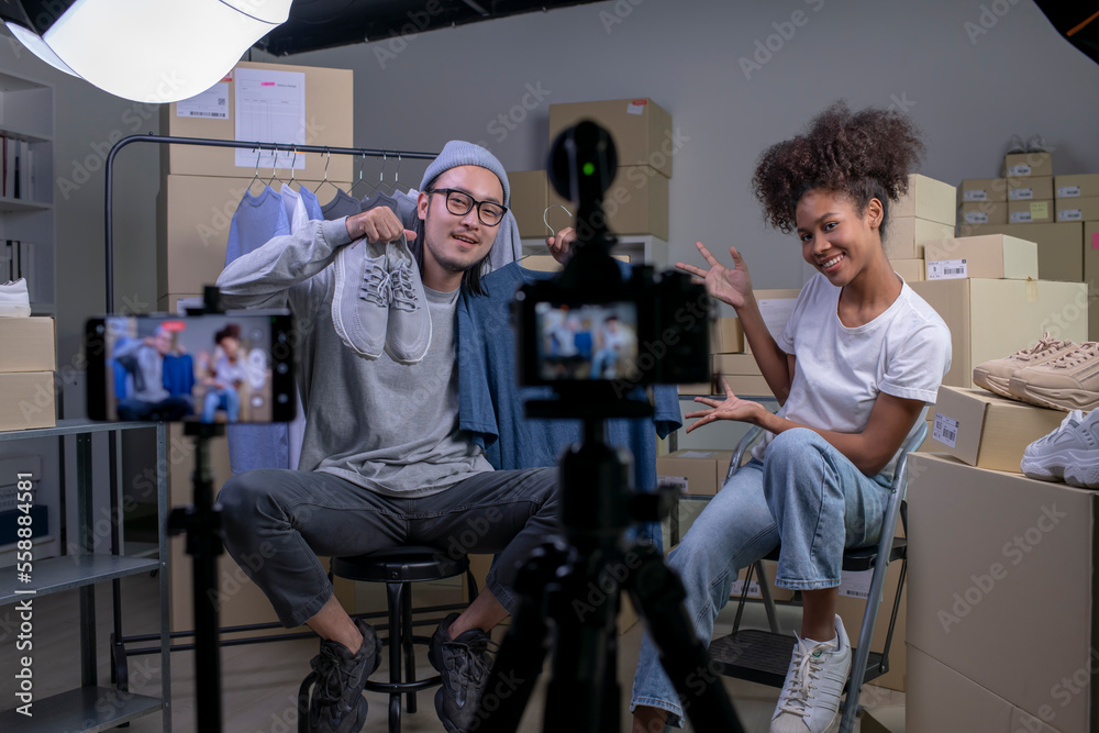 Mixed race couple of Asian man and African-American woman blogger or vlogger looking at camera reviewing product. Mixed race couple of Asian man and African-American woman blogger or vlogger looking at camera reviewing product.
