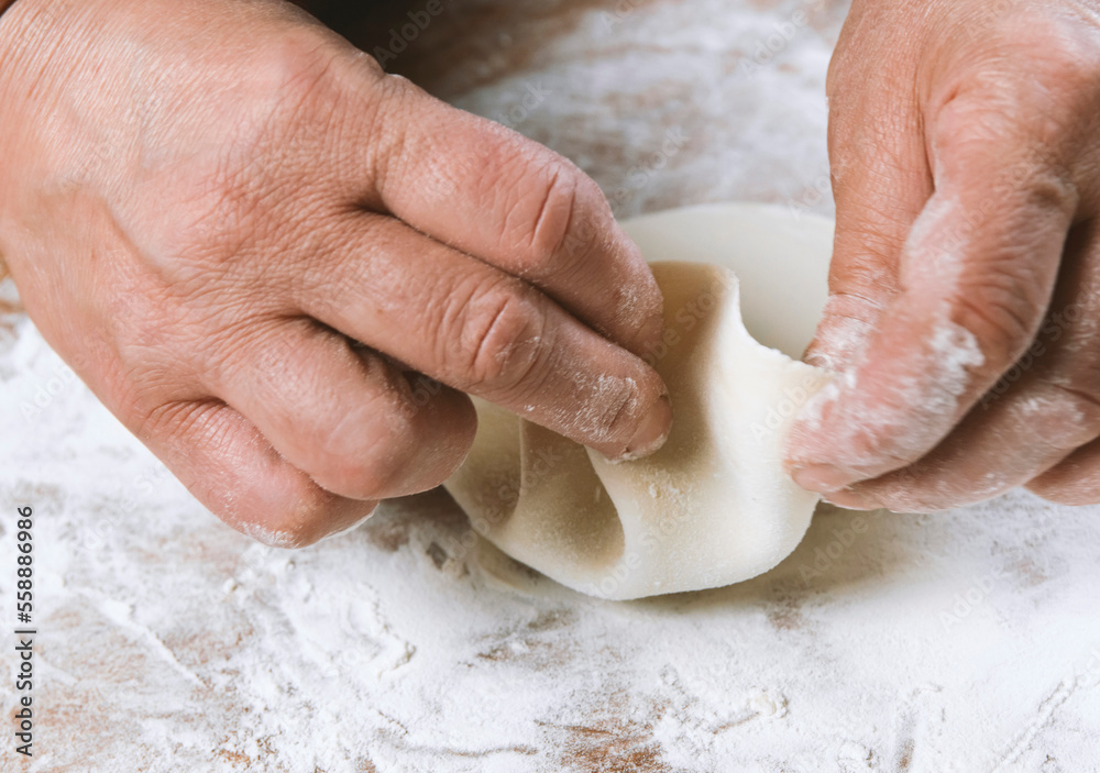 Fototapeta premium Chef cook making dumplings, manti, khinkali on wooden table. Process preparation georgian meal. food concept.