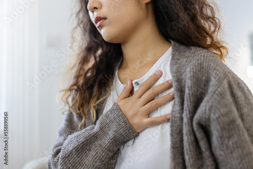 Foto Stressed young woman feeling pain and touching chest suffer from heartache disea