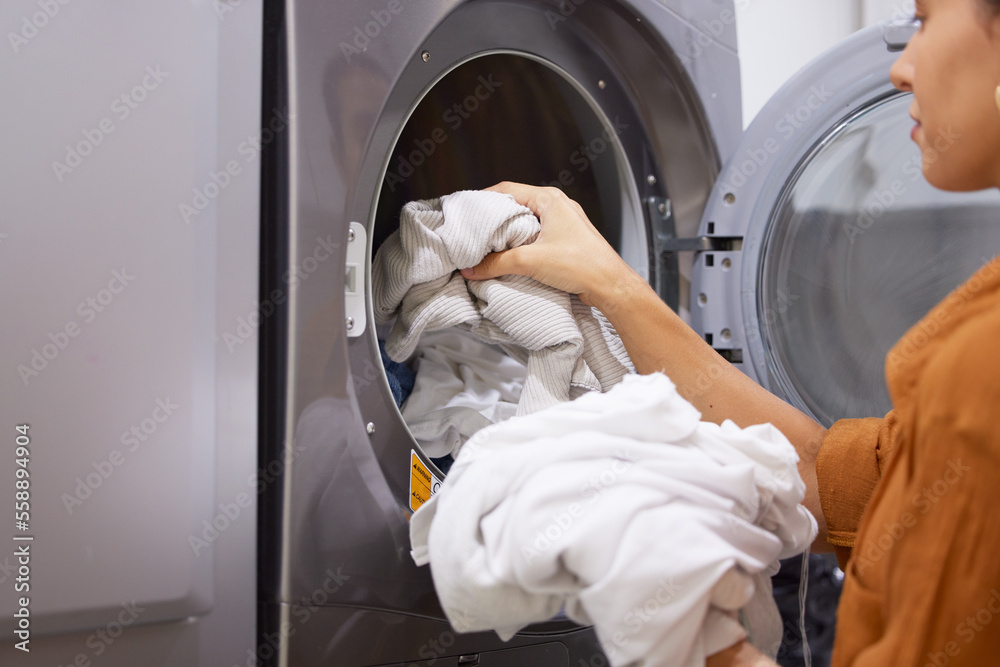 Laundry, cleaning and woman with clothes in the washing machine for housekeeping, clean fabric and home spring cleaning. Service, clean and cleaner at a laundromat for morning housework routine Laundry, cleaning and woman with clothes in the washing machine for housekeeping, clean fabric and home spring cleaning. Service, clean and cleaner at a laundromat for morning housework routine