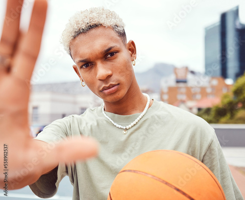 Sports, selfie and basketball player with fashion with a ball standing on an outdoor court. Fitness, edgy and cool man model and athlete from Brazil posing for a picture with a casual outfit in city