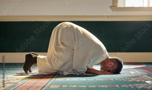 Islam, religion and prayer of a muslim man at mosque in ramadan for spiritual faith, God and belief while doing religious worship. Islamic or Arab culture people sitting to pray at holy place
