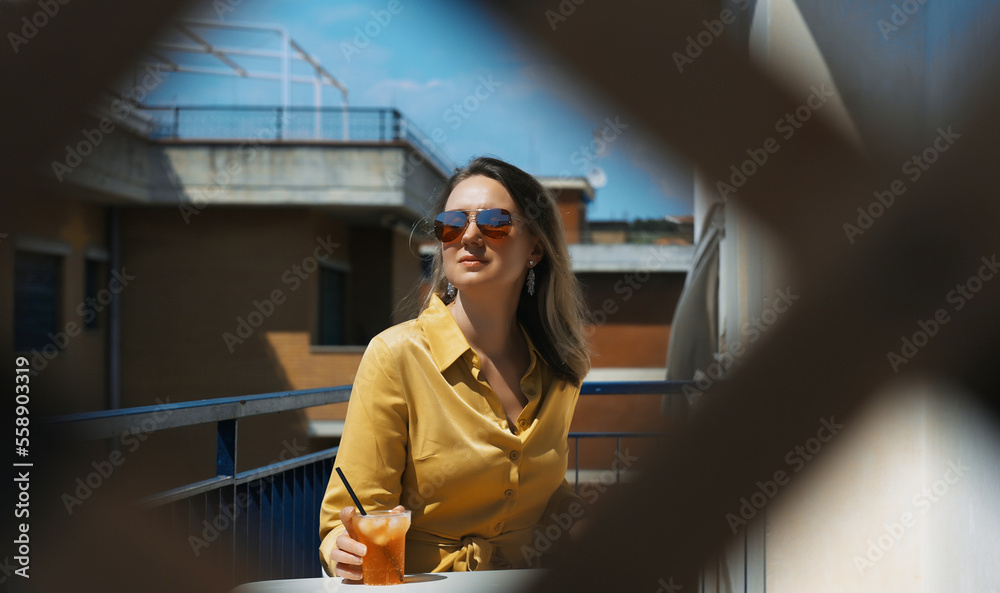Fototapeta premium Woman enjoys the summer while sitting on the balcony.