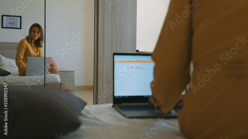 Woman works on a computer in the bedroom. © M-Production