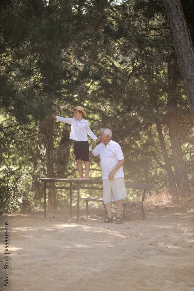 Happy senior man Grandfather with cute little boy grandson playing in forest Happy senior man Grandfather with cute little boy grandson playing in forest