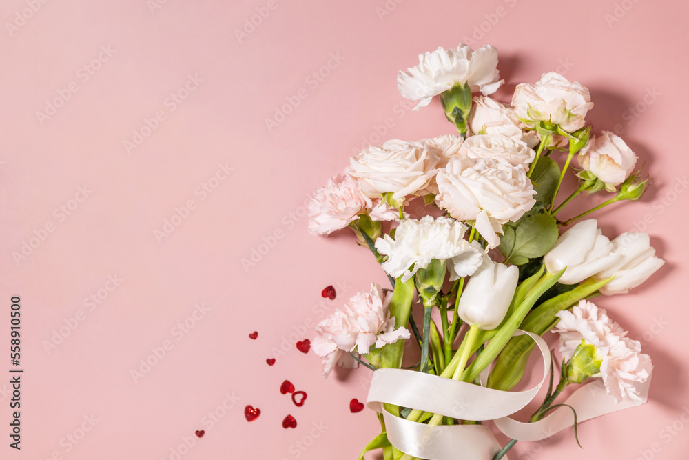 Valentine's Day greeting card with beautiful flowers and hearts on pink background. Valentine's day, Womans day, wedding, birthday or mothers day. View from above. Copy space.