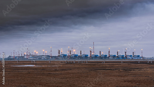 Infrastructure of a complex installation for the preparation of natural gas for transportation via a gas pipeline. The Arctic zone of Siberia. Gloomy autumn sky. In the foreground is the polar tundra © mangz