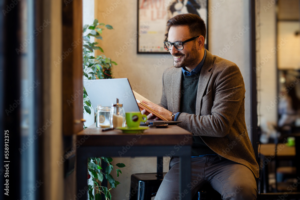 Businessman Reading Book while Sitting in Cafe Businessman Reading Book while Sitting in Cafe