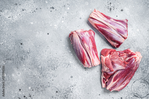 Uncooked Raw lamb shanks, mutton meat on kitchen table. Gray background. Top view. Copy space