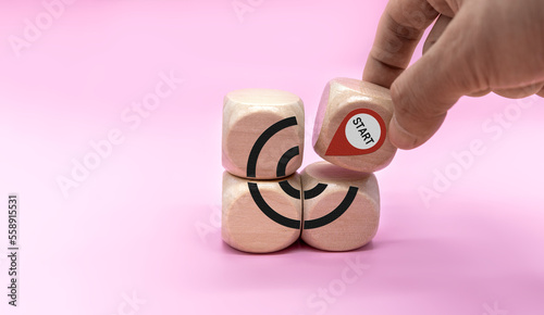 Starting point and a wooden cube with an arrow pointing to the target icon. Growing business success concept