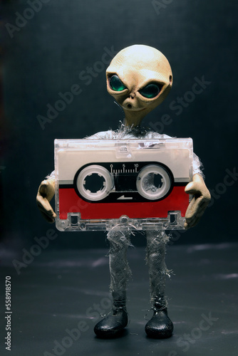 alien with a microcassette in his arms photo