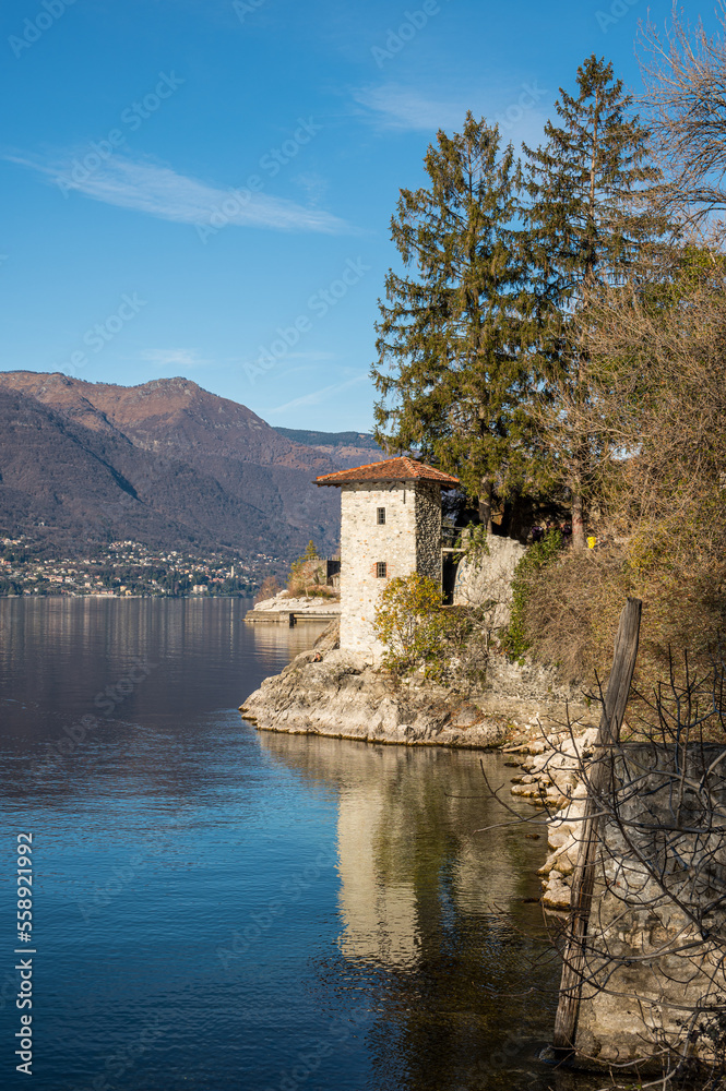Old ruined furnaces with chimneys with red bricks reflecting on the water of Lake Maggiore in the Parco delle Fornaci in Caldè