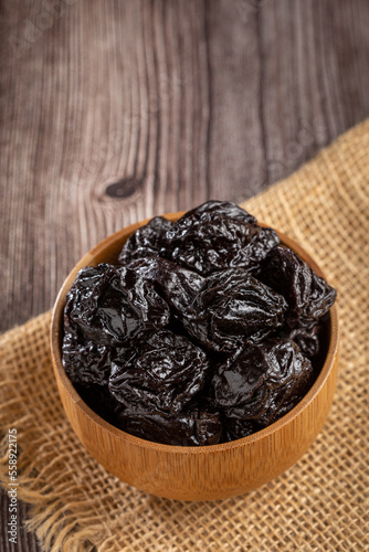 Bowl with prunes on the table.