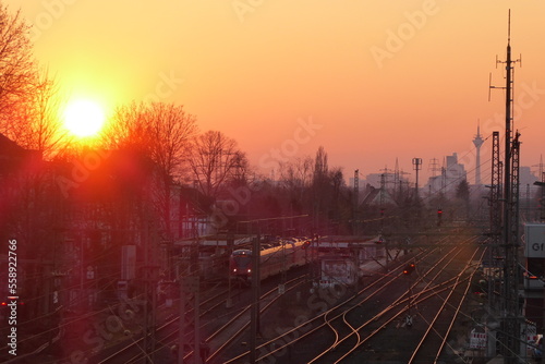 Sunset at Dusseldorf Gerresheim train station with a train and the skyline in Germany