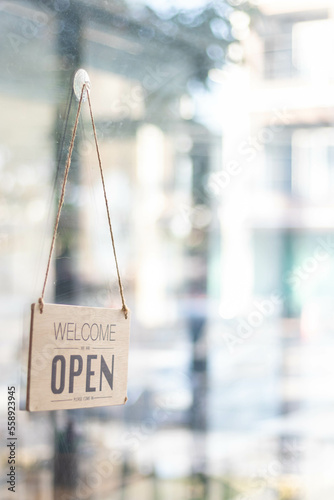 The store open sign is installed around the glass door in front of the store so that customers can see the store open sign and come to use the service in the coffee shop, startup business concept.