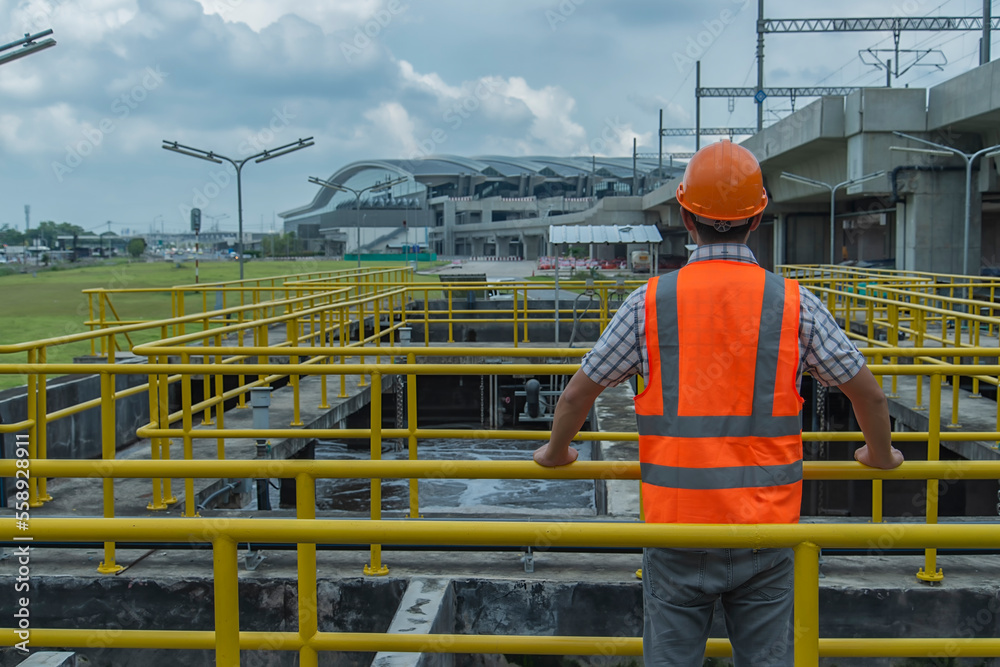 construction worker at work. service engineer checking on waste water treatment plant with pump on background. worker working on Waste water plant. construction worker at work. service engineer checking on waste water treatment plant with pump on background. worker working on Waste water plant.