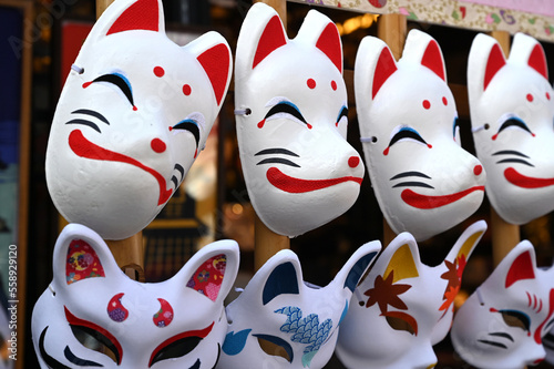 日本のお祭りで狐と猫のお面が並ぶ風景