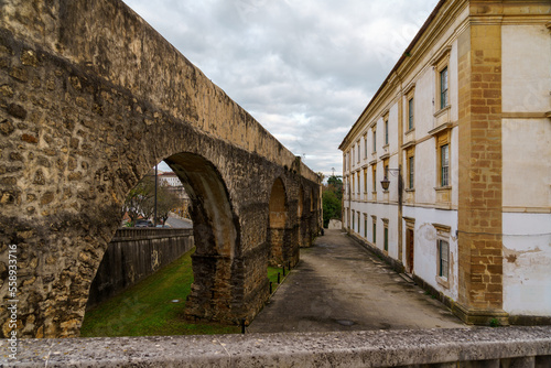 remnants of an old roman aqueduct in the european city of coimbra