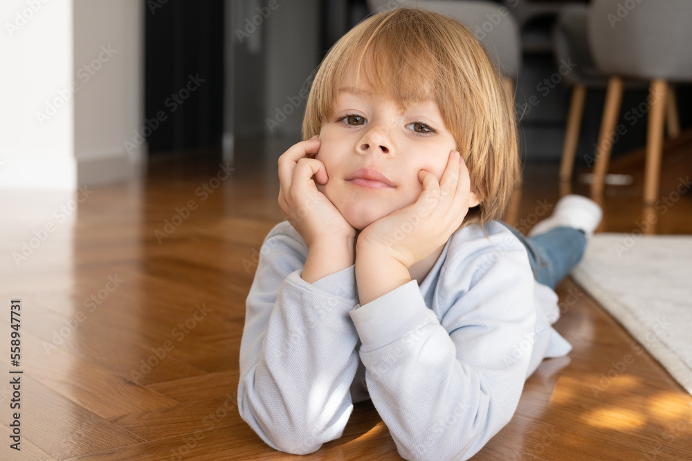 A 4 year old boy boy holding his head in his hands -- image taken indoors using natural light A 4 year old boy boy holding his head in his hands -- image taken indoors using natural light