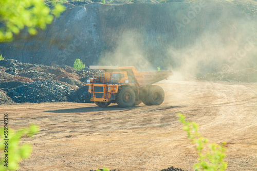 Large quarry dump truck to remove the rock mass from the quarry for the extraction of minerals. Truck on the road at the waste rock dump during ore mining