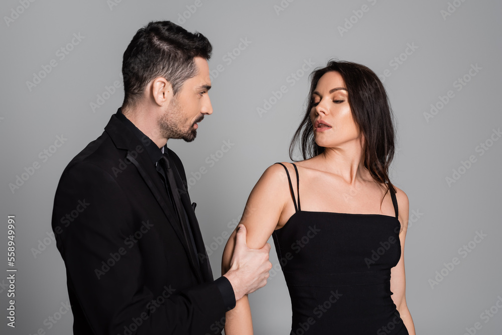bearded man pulling hand of brunette and sexy woman isolated on grey. bearded man pulling hand of brunette and sexy woman isolated on grey.