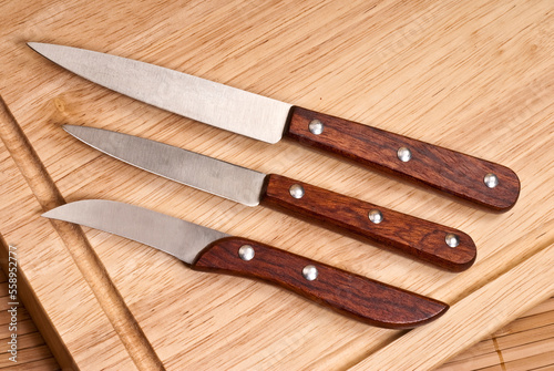 service de trois couteaux de cuisine sur une planche à découper photo