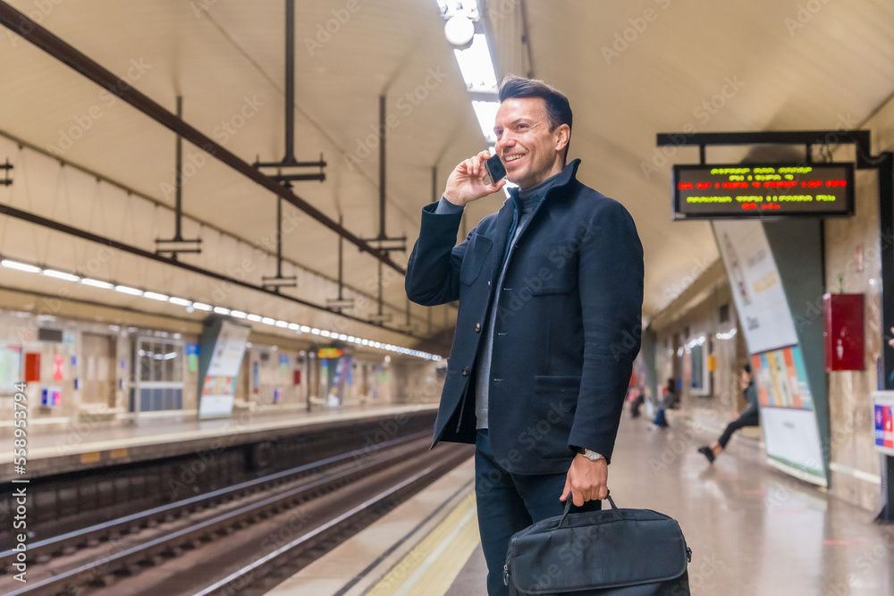 Middle-aged Caucasian businessman, waiting on the subway for the train to go to work, talking on the phone