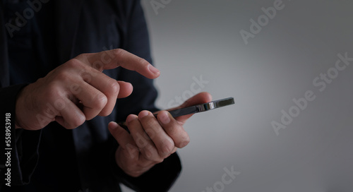 Businessman is using hand to press smartphone, concept of using mobile phone to communicate with people, communication, data connection