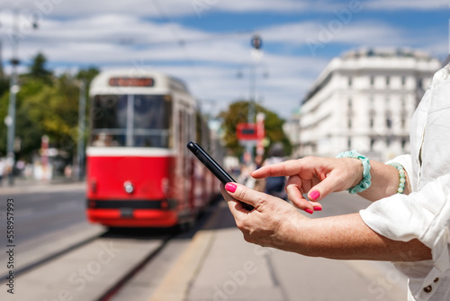 Photography Woman buying online ticket to tramway with mobile app on her smart phone