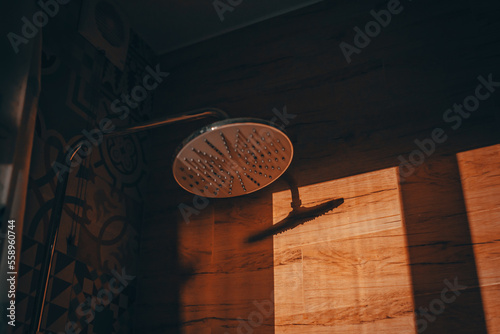 Shower watering can in the bathroom with a shadow on the wall