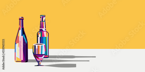 Various multi-colored bottles with wine and beer and a glass next to them. There is a copy space nearby.