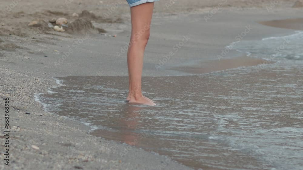 woman girl legs walking on beach seashore ocean sands.female playing with feet barefoot sole in water water sitting on big rock coast line close up 4k real time video summer vacation trip travel woman girl legs walking on beach seashore ocean sands.female playing with feet barefoot sole in water water sitting on big rock coast line close up 4k real time video summer vacation trip travel