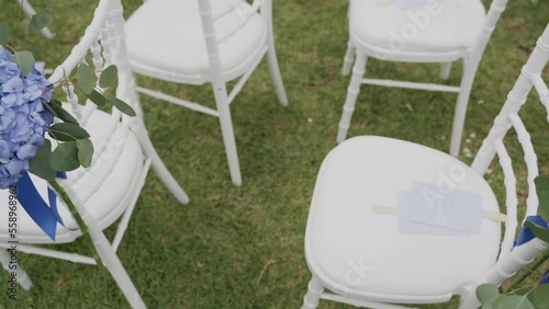 White wedding chairs with blue peonies on it