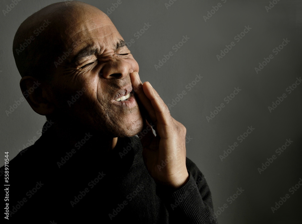 man with toothache in severe pain on grey background stock photo man with toothache in severe pain on grey background stock photo