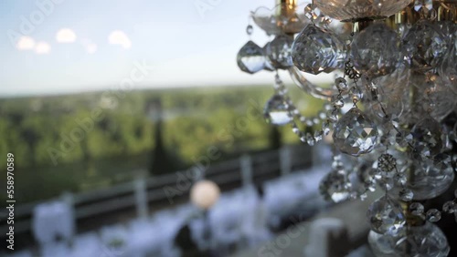 Detail of a crystal drops chandelier in the foreground. 