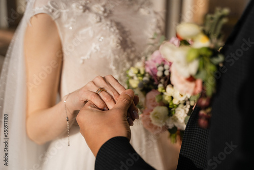 the groom holds the bride's hand close-up