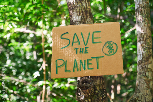 Cardboard sign written Save the planet in the jungle. Concept of environmental conservation, forests and jungles.