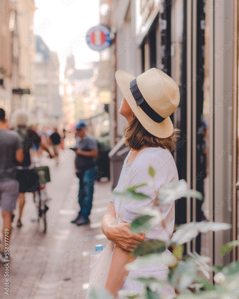 A beatiful lady with a white hat and white dress in the streets of Amsterdam, Netherlands