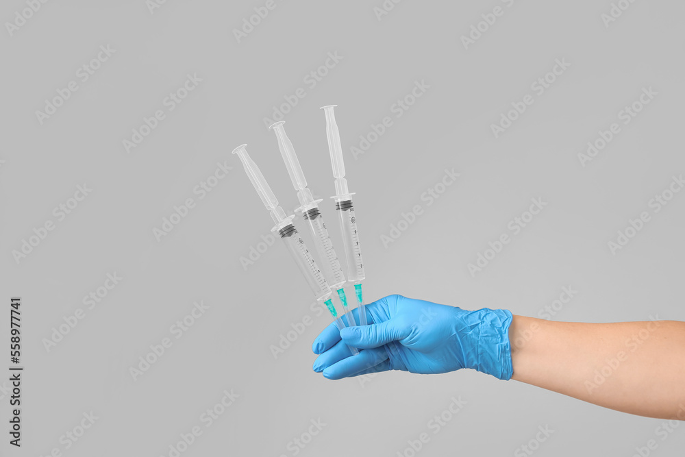 Syringes filled with vaccine in doctor's hand.