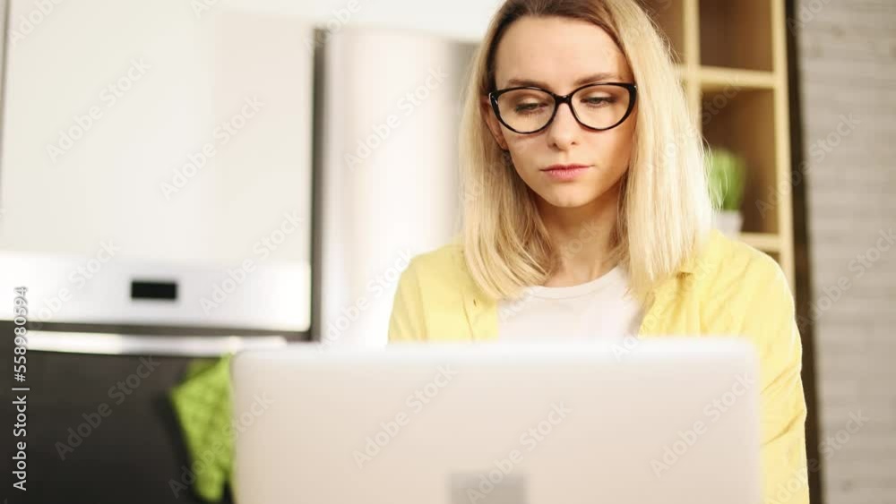 Portrait of attractive young woman student freelancer with glasses using laptop computer at home Charming blond female doing online job working studying or browsing web with warm sunlight indoors Portrait of attractive young woman student freelancer with glasses using laptop computer at home Charming blond female doing online job working studying or browsing web with warm sunlight indoors