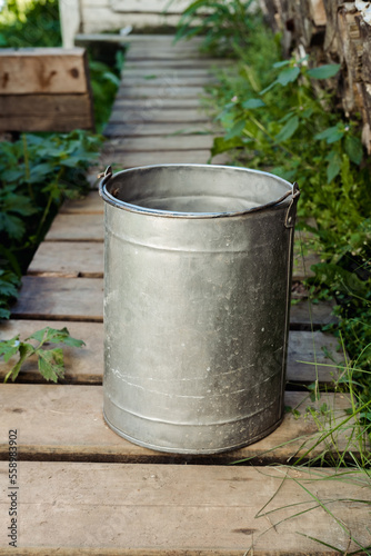 iron bucket with water in the country in the summer