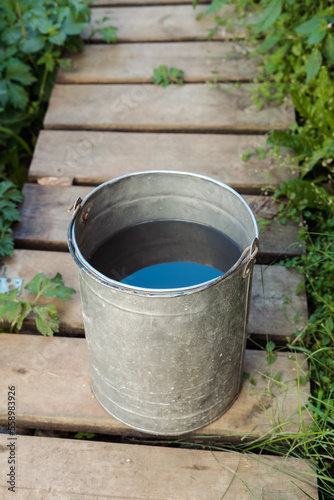 iron bucket with water in the country in the summer, top view