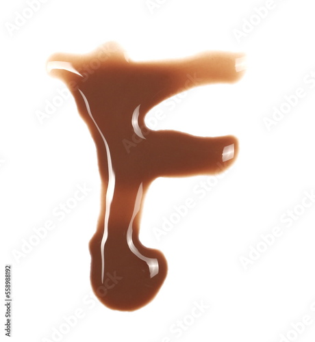 Spilled chocolate milk puddle in shape letter F isolated on white background, top view